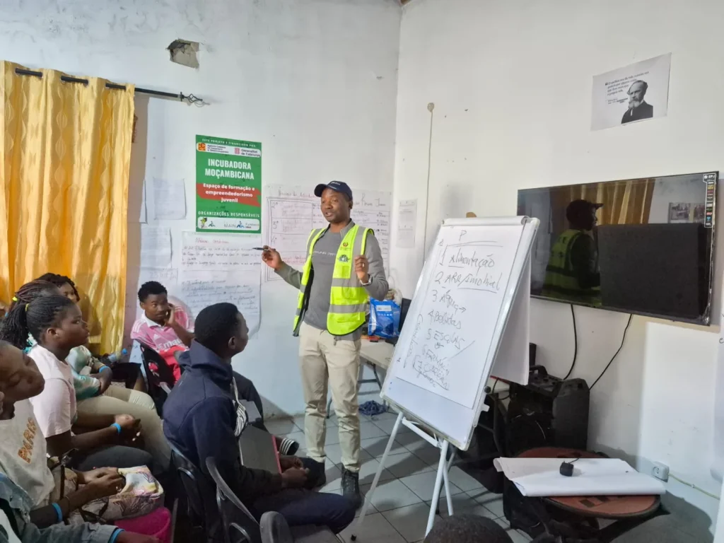 Trainer presenting at a board during a youth capacity-building session