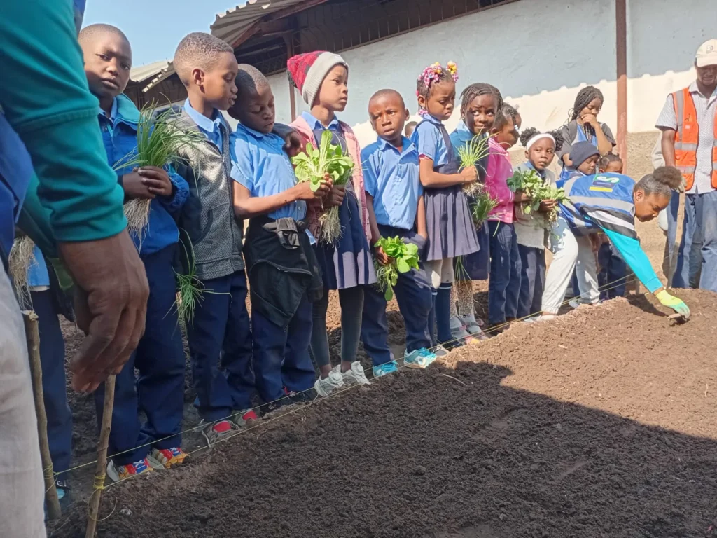 Instructors teaching children how to plant seedlings